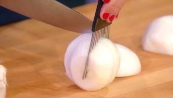 chopping an onion using a hair pick to hold it steady