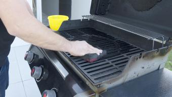person cleaning gas grill
