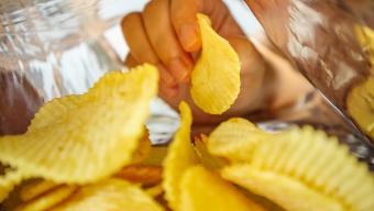 hand reaching into potato chip bag