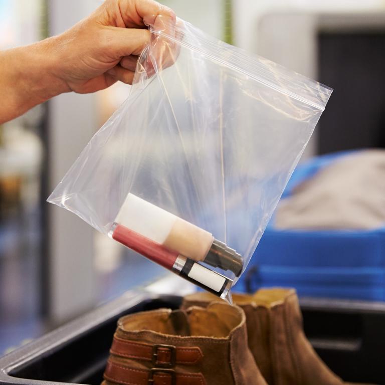 woman's hand holding plastic bag with liquids at airport security