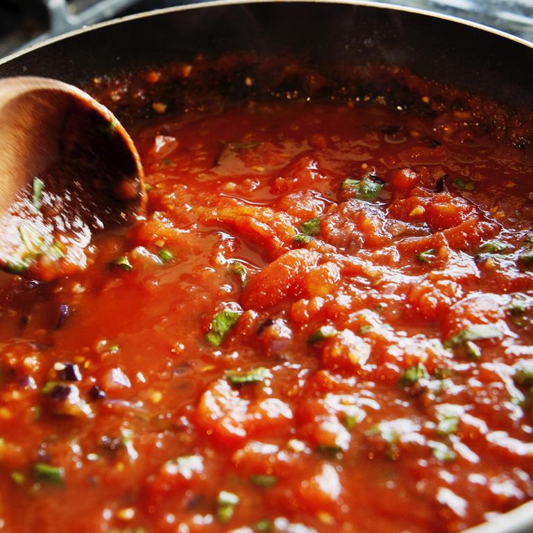 big pot of tomato sauce cooking on stove