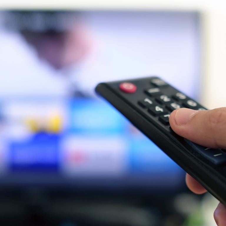 hand pointing remote at TV to choose what to watch