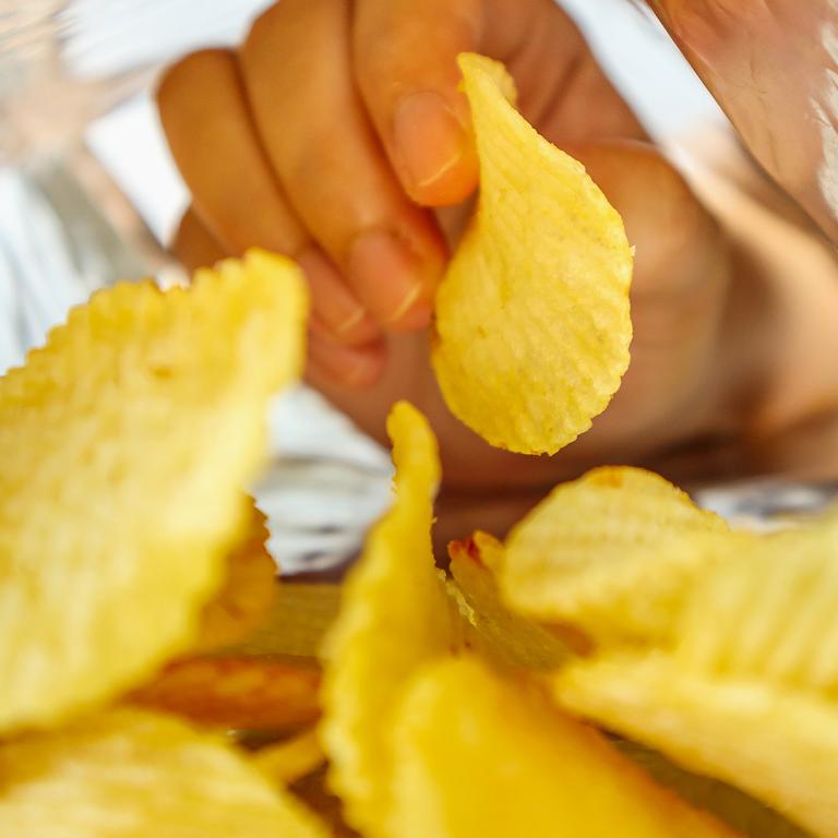 hand reaching into potato chip bag