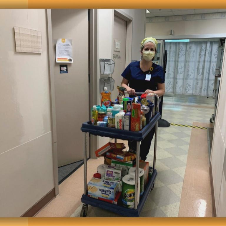 Stacy with cart full of pantry items at hospital