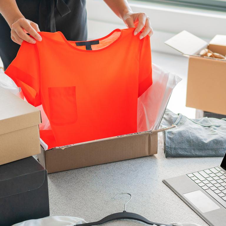 person opening box of clothes ordered online